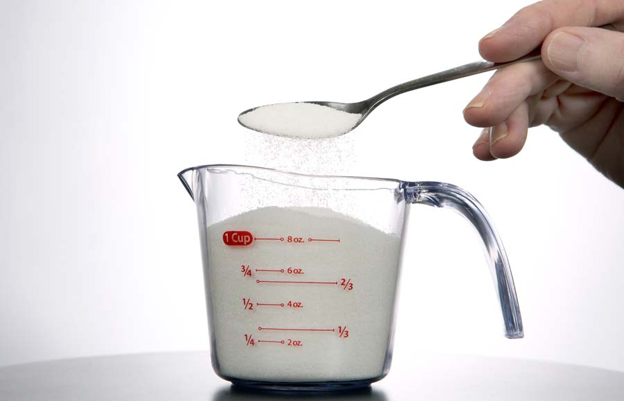 Measuring tablespoons into a cup (cup measurement in glass jug)